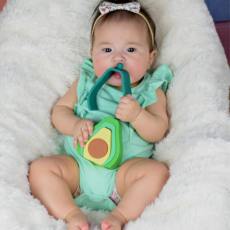 baby chewing on safe silicone stacker avocado